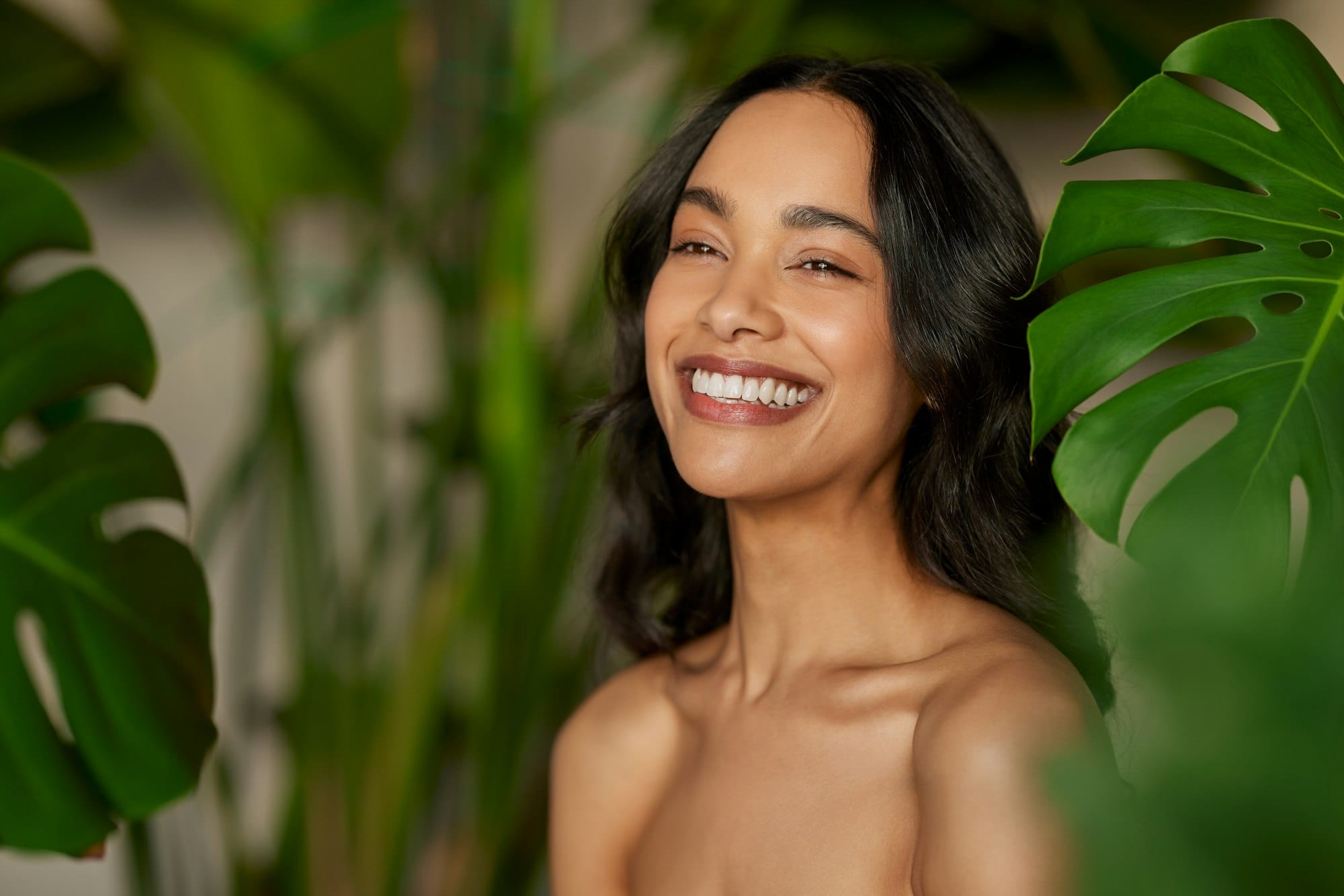 Beautiful natural woman with monstera leaves